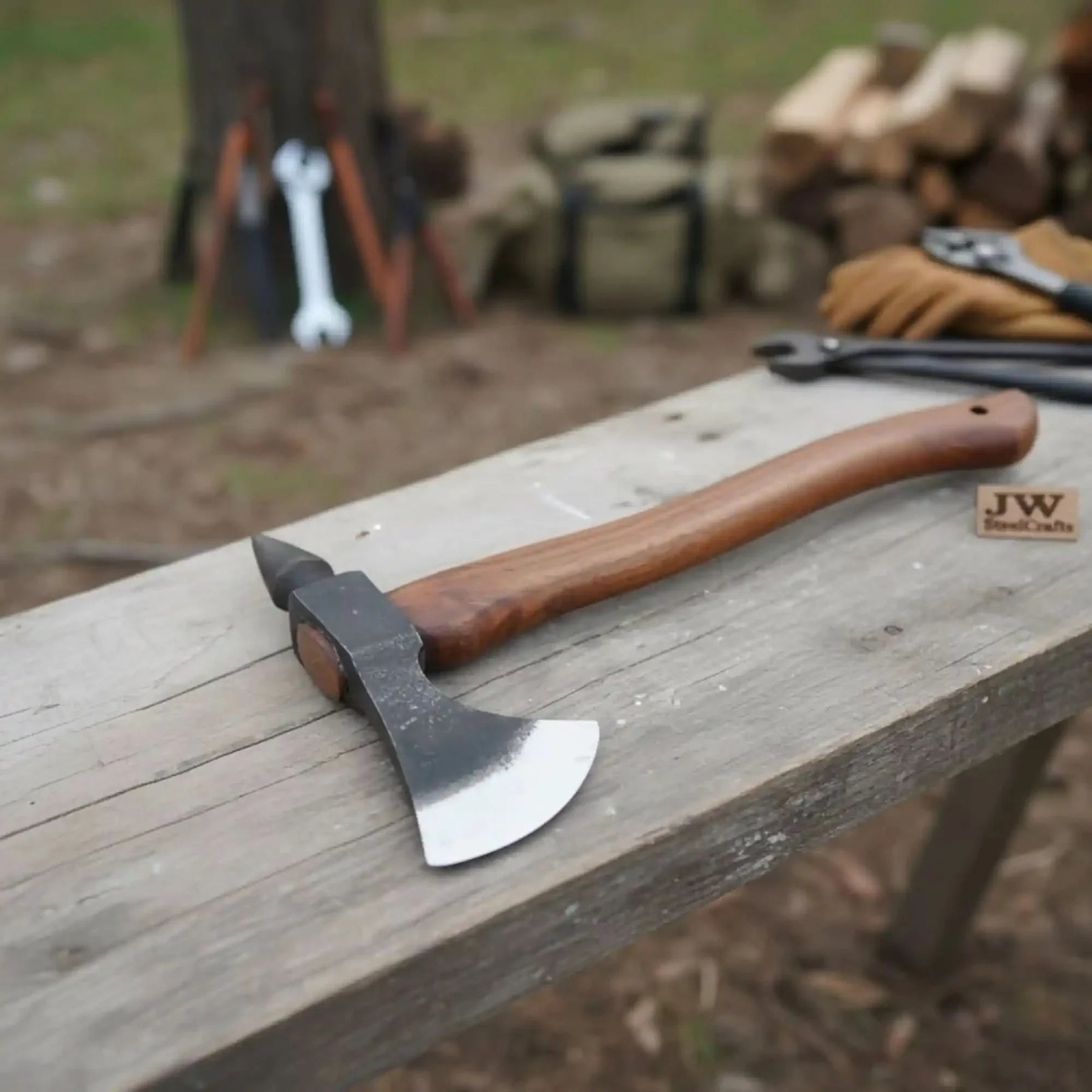 Damascus steel axe head with wood handle on rustic wood surface