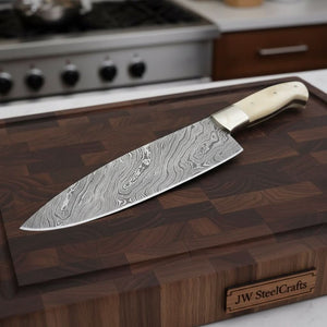 Handmade damascus steel knife with bone handle on dark surface