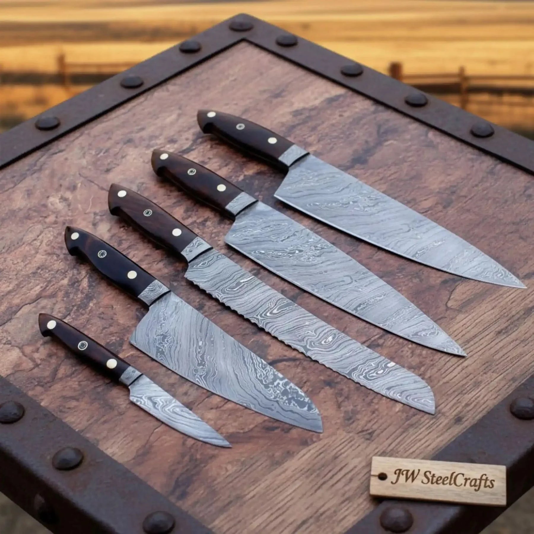 Handmade damascus steel knife with wood handle on dark surface
