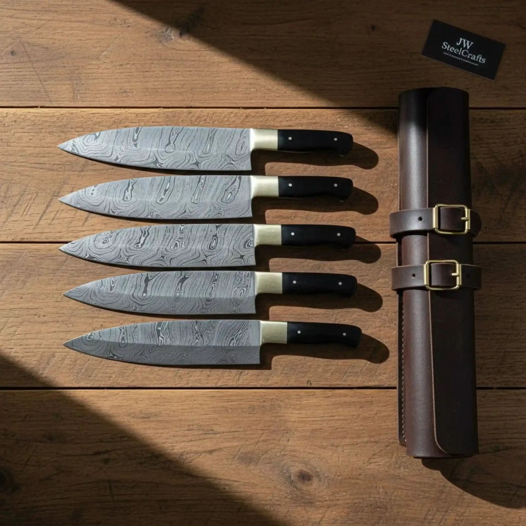 Handmade damascus steel knife with wood handle on dark surface