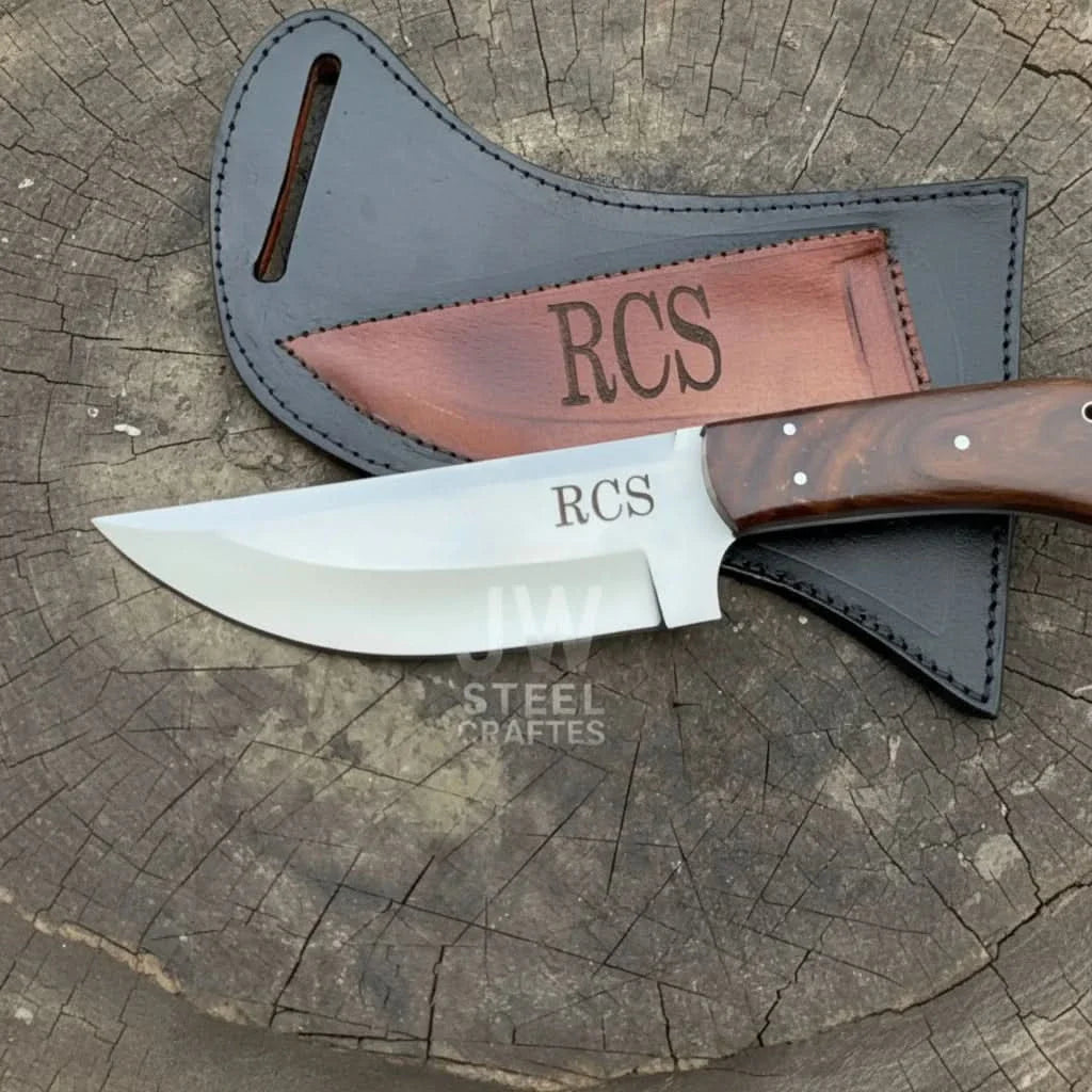 Handmade stainless steel steel knife with walnut handle on dark surface