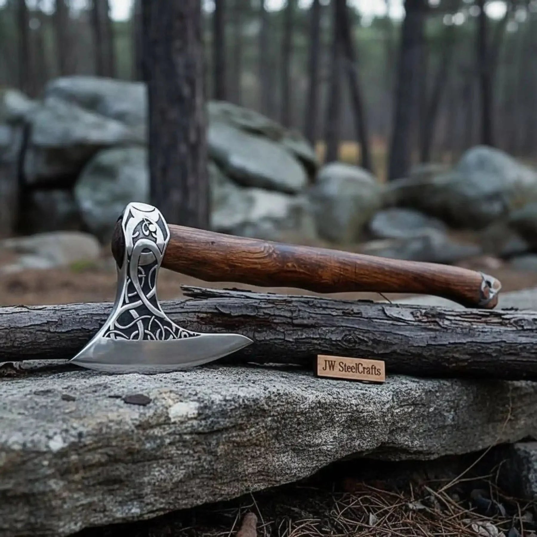 Damascus steel axe head with wood handle on rustic wood surface