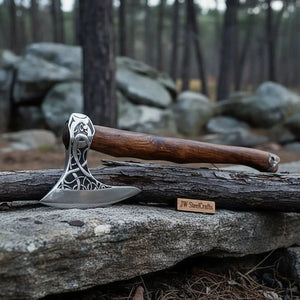 Damascus steel axe head with wood handle on rustic wood surface