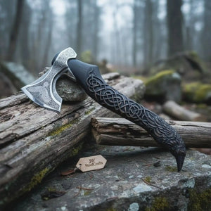 Damascus steel axe head with wood handle on rustic wood surface