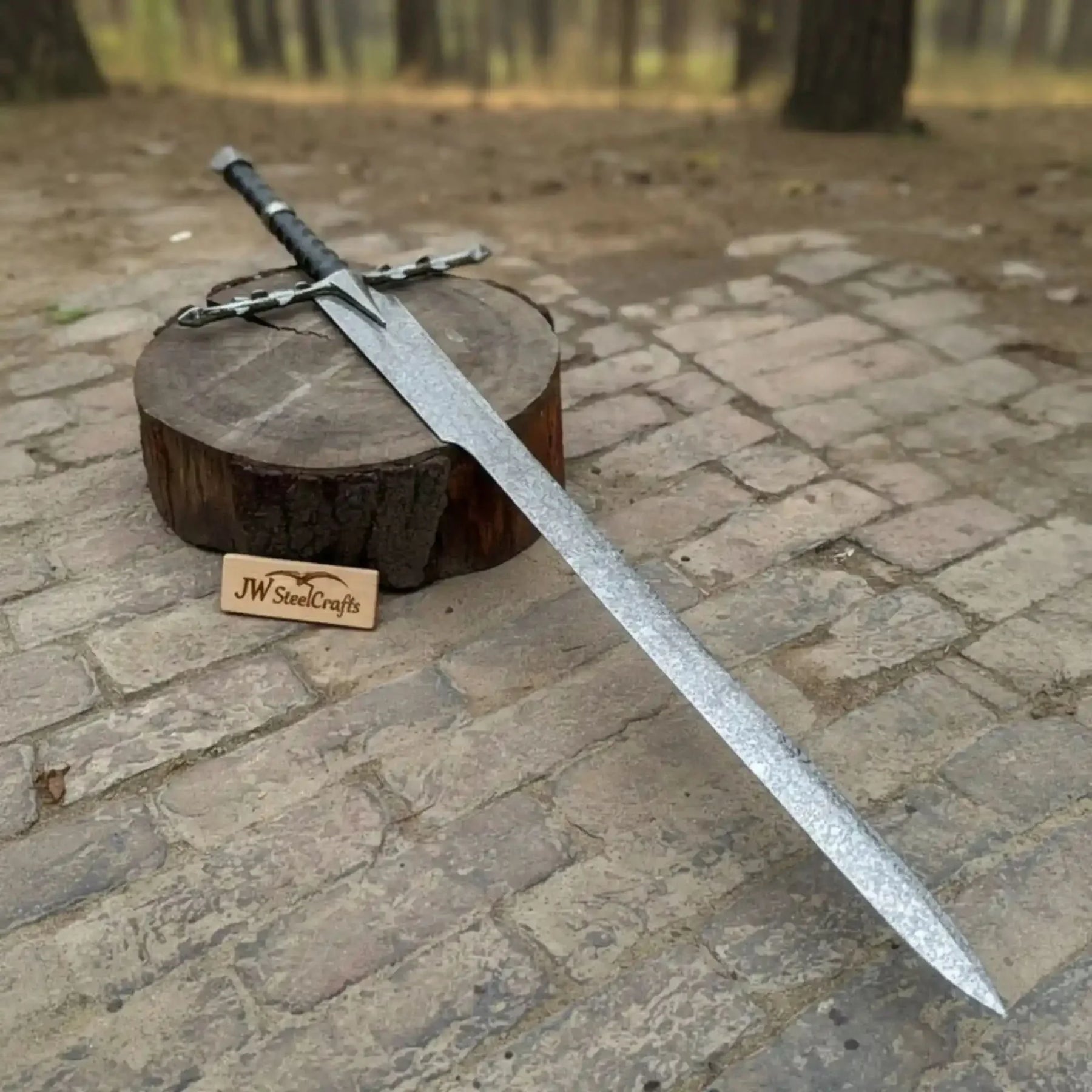Full-length carbon steel steel replica sword with horn handle on dark background