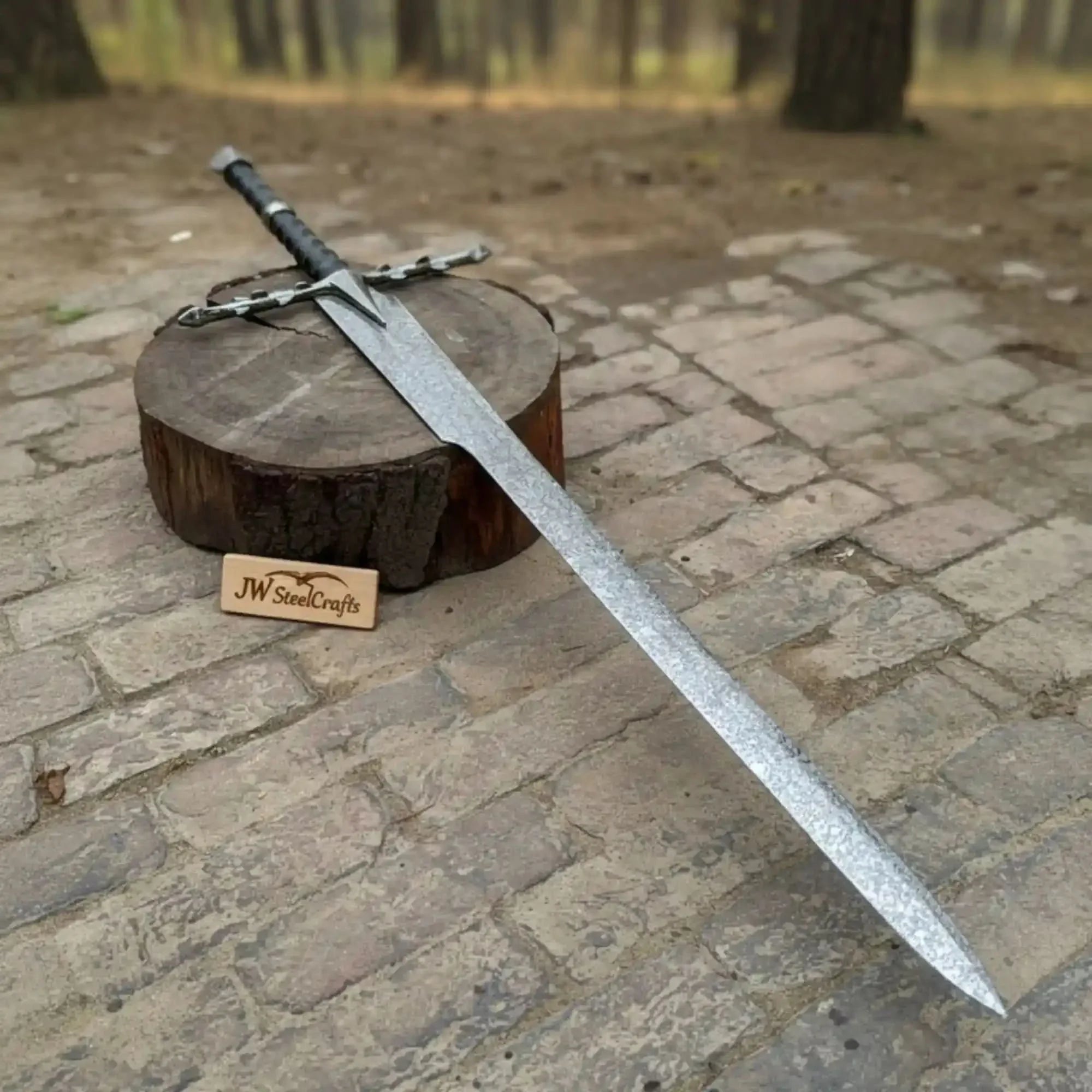 Full-length carbon steel steel replica sword with horn handle on dark background