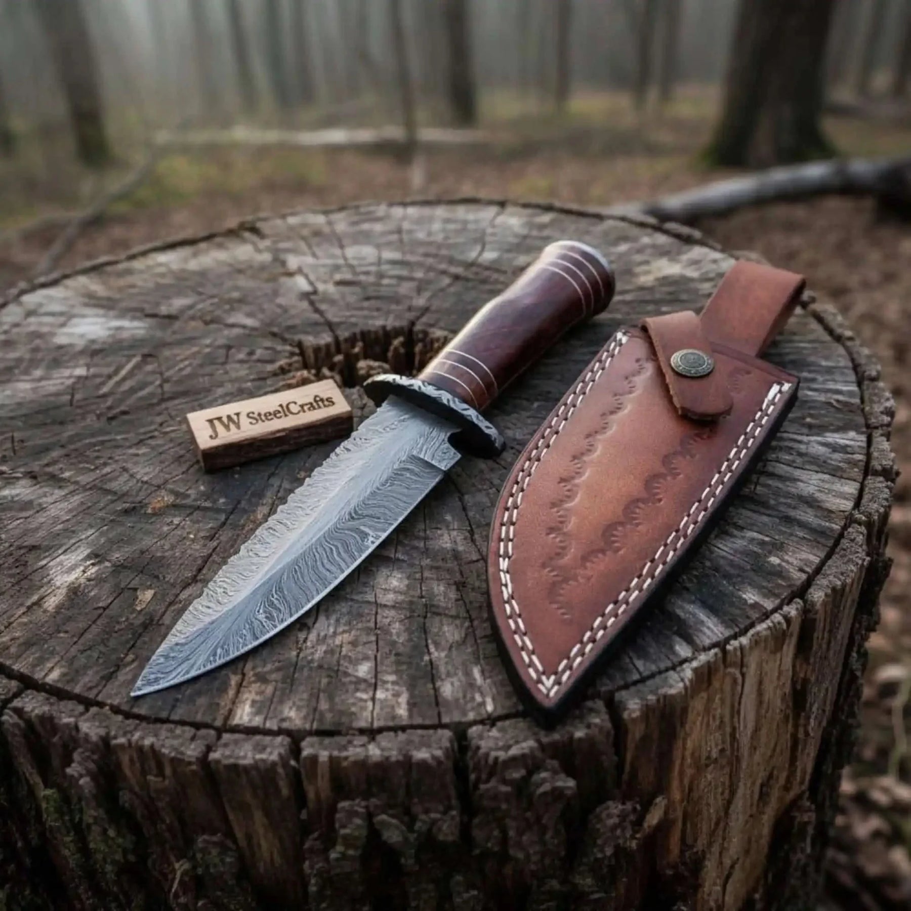 Handmade damascus steel knife with wood handle on dark surface
