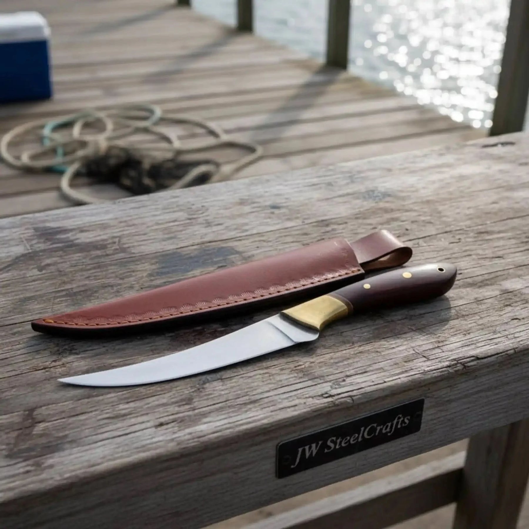Handmade damascus steel knife with wood handle on dark surface