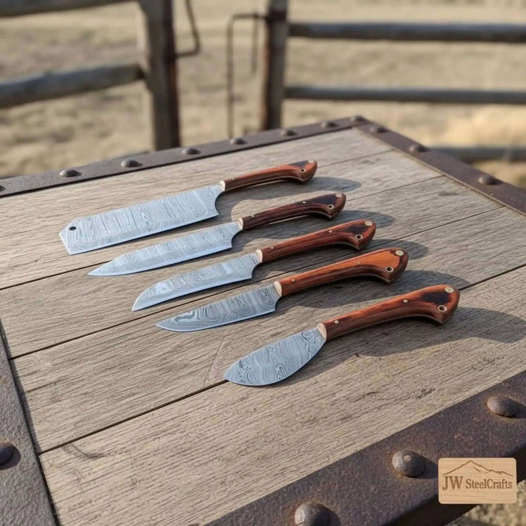 Handmade damascus steel knife with wood handle on dark surface
