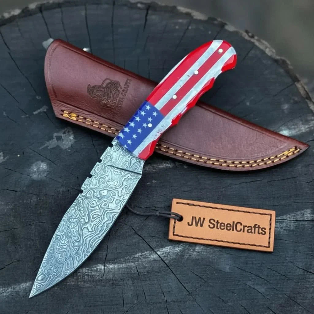 Handmade damascus steel knife with leather handle on dark surface