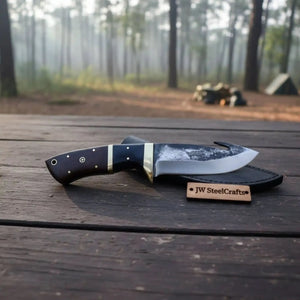 Handmade damascus steel knife with wood handle on dark surface