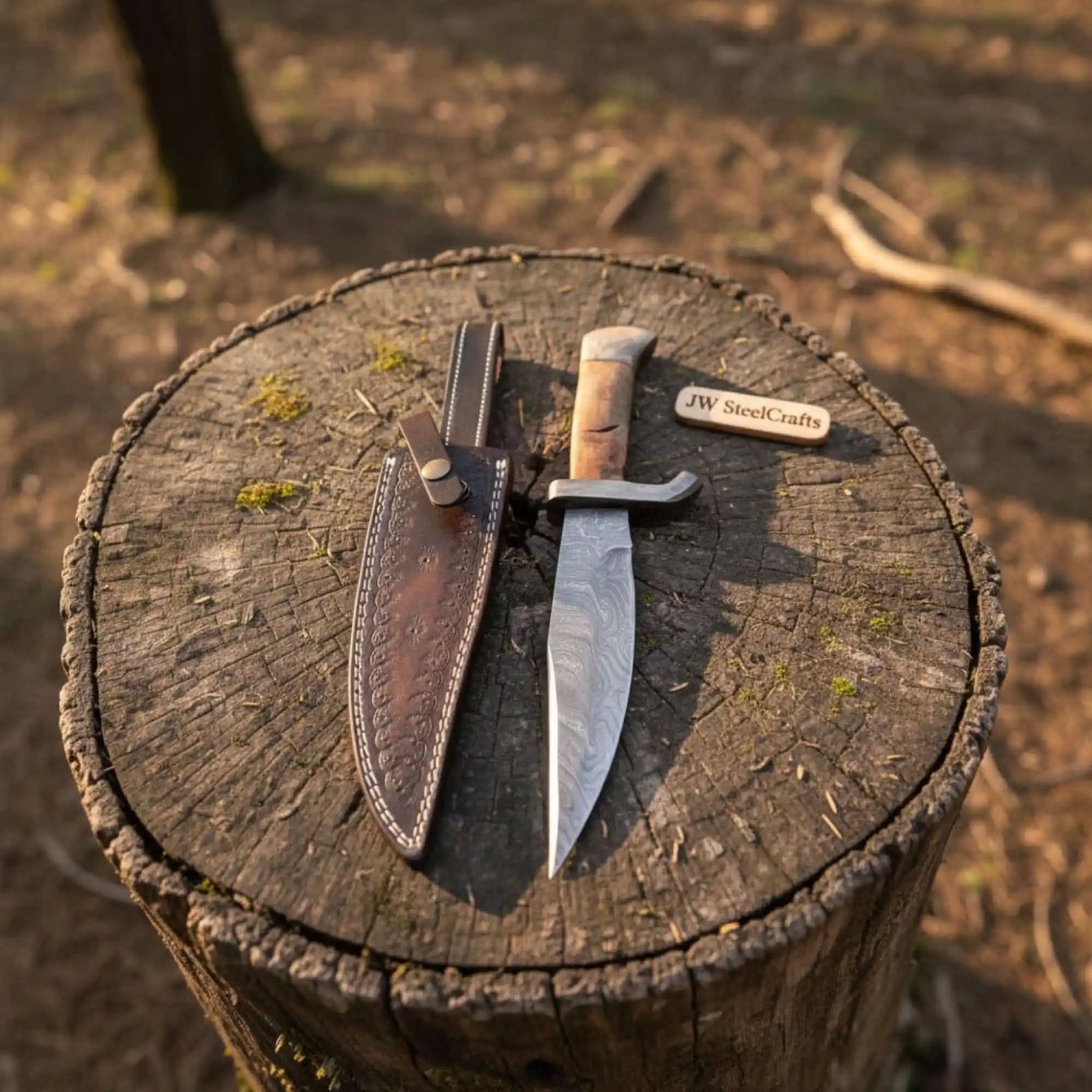 Handmade damascus steel knife with wood handle on dark surface