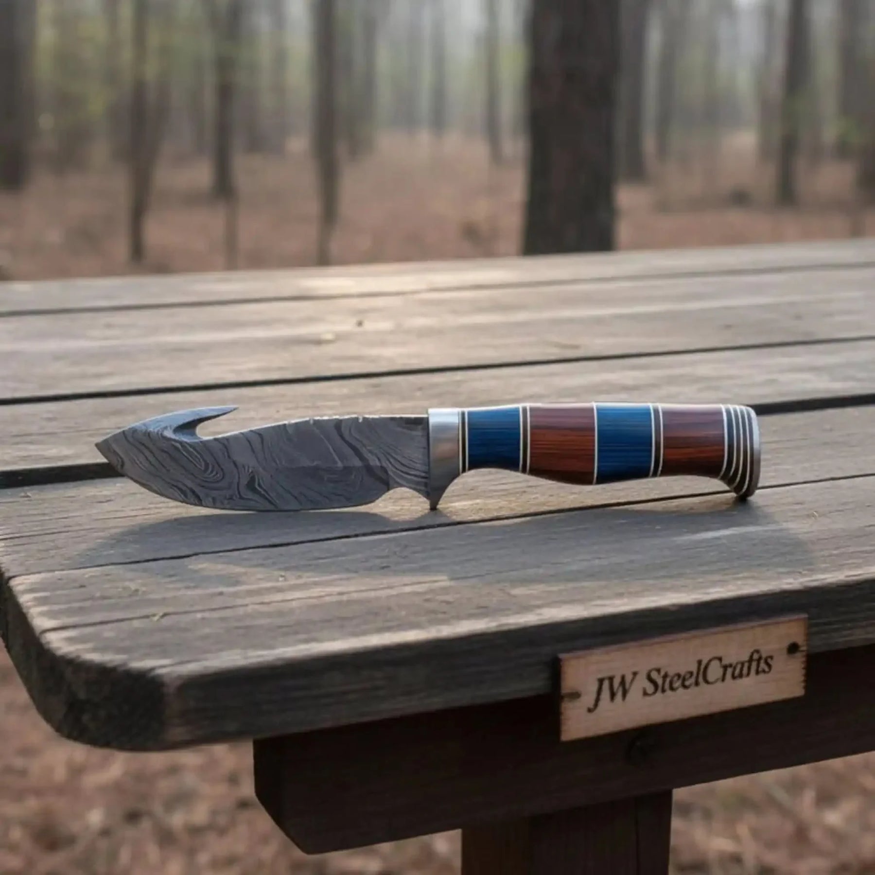 Handmade damascus steel knife with premium handle on dark surface