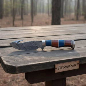 Handmade damascus steel knife with premium handle on dark surface