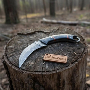 Handmade damascus steel knife with premium handle on dark surface