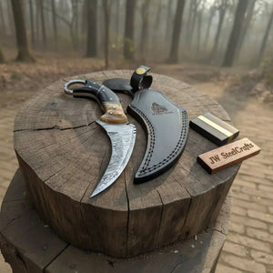 Handmade damascus steel knife with horn handle on dark surface