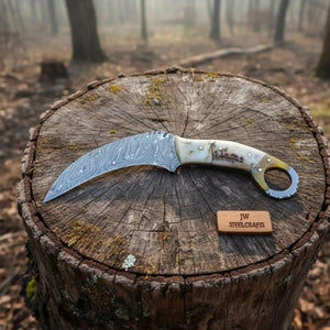 Handmade damascus steel knife with premium handle on dark surface