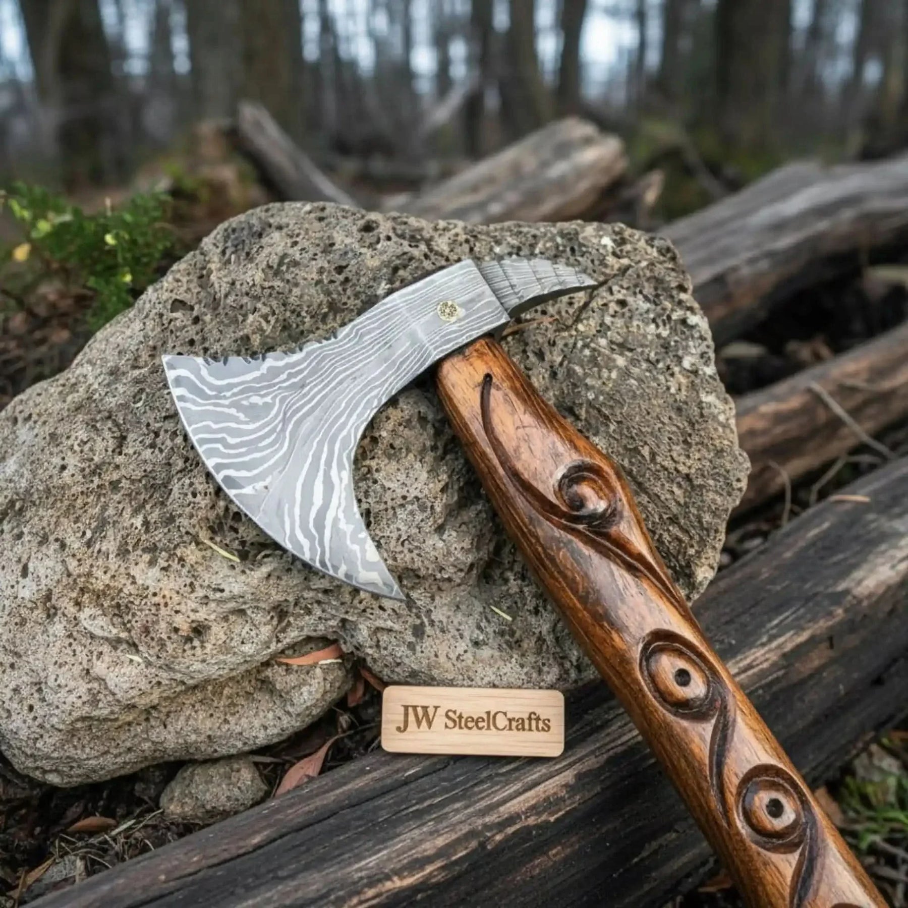 Damascus steel axe head with wood handle on rustic wood surface