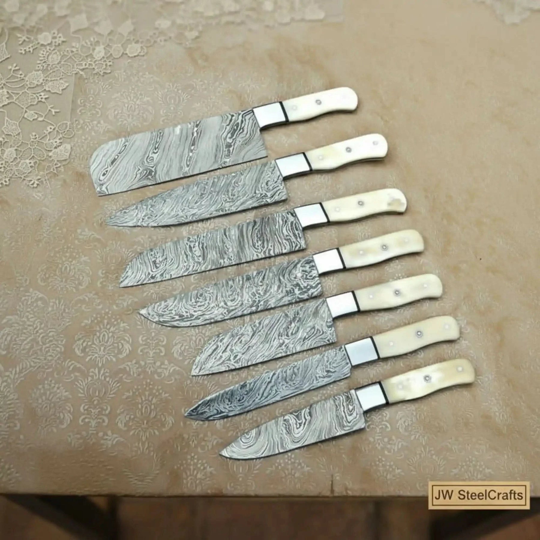 Handmade damascus steel knife with bone handle on dark surface