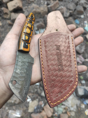 Handmade damascus steel knife with premium handle on dark surface