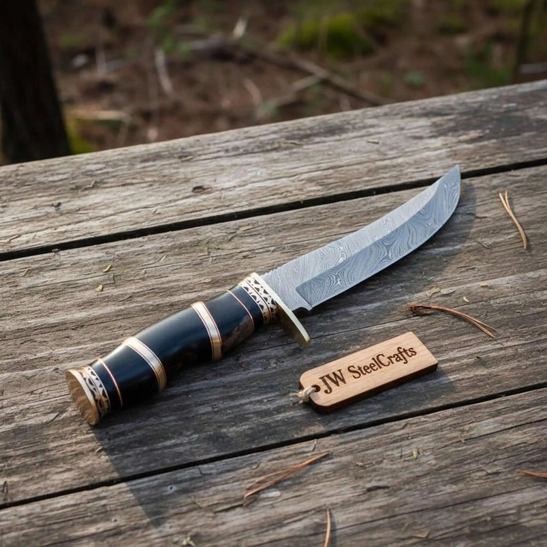 Handmade damascus steel knife with premium handle on dark surface