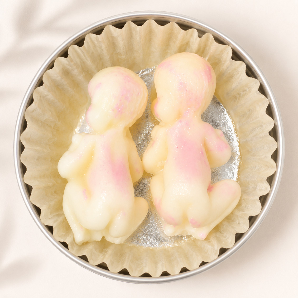 Little Baby Lotion Bars in an open tin with soft cream and pink marbled solid lotion bars