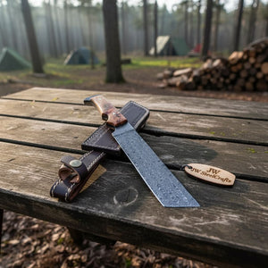 Handmade damascus steel knife with wood handle on dark surface