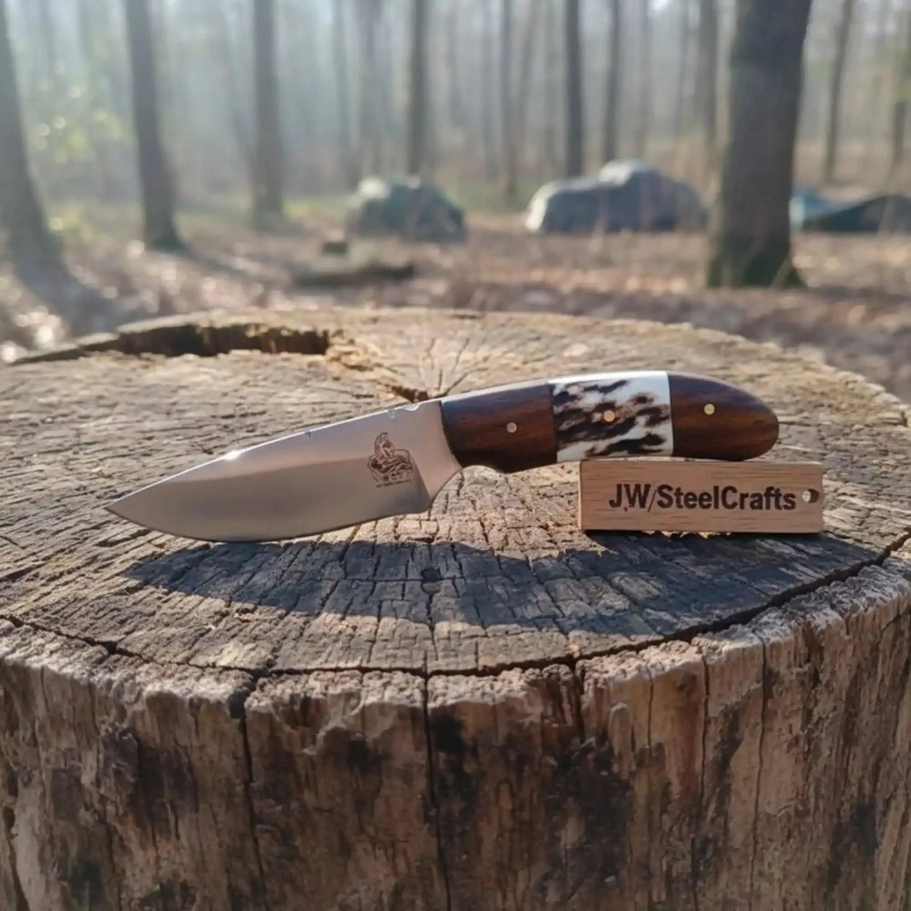 Handmade damascus steel knife with wood handle on dark surface