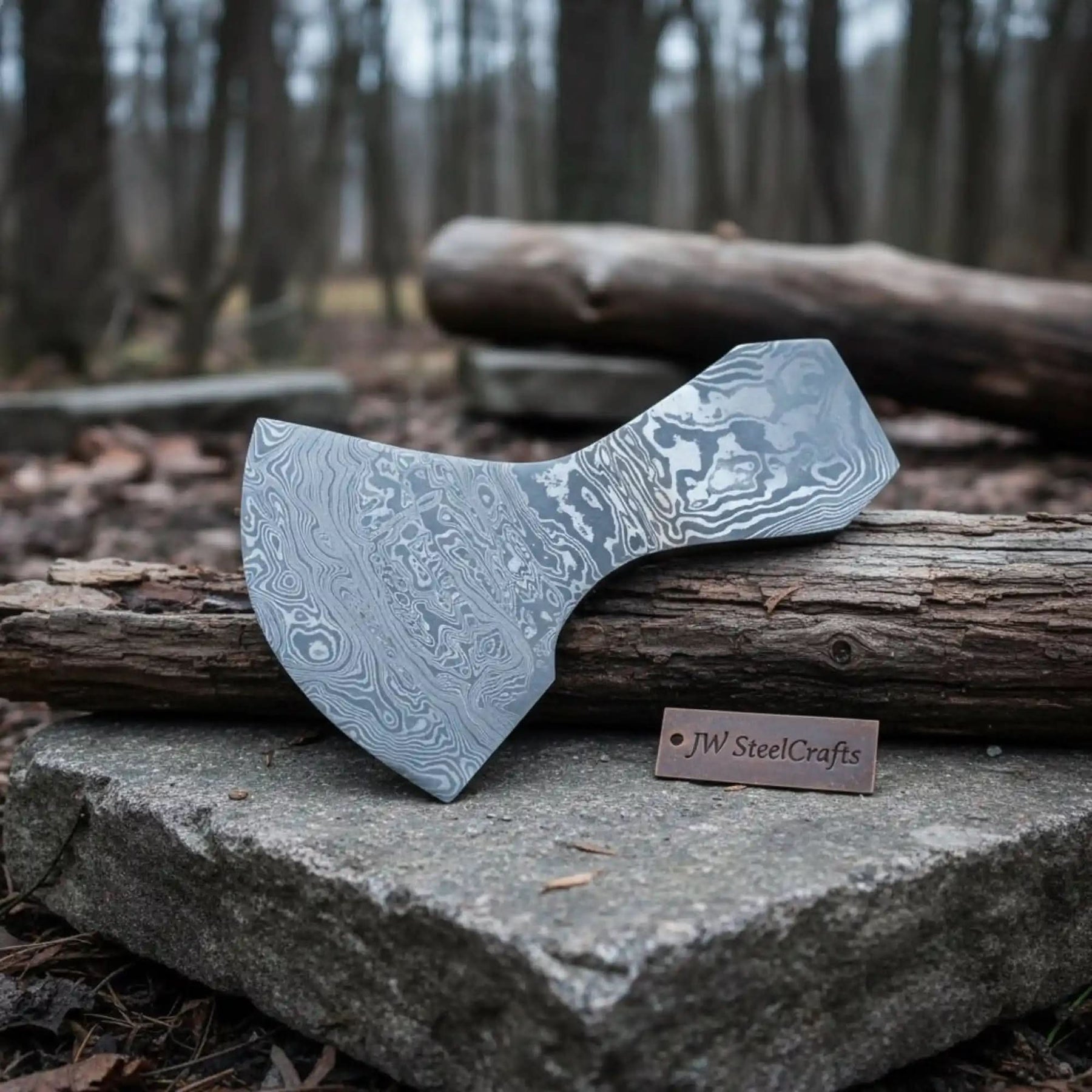 Damascus steel axe head with premium handle on rustic wood surface