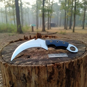 Handmade damascus steel knife with wood handle on dark surface