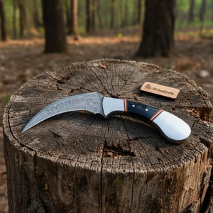 Handmade stainless steel steel knife with horn handle on dark surface