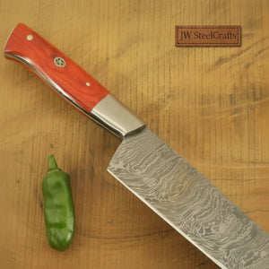 Handmade damascus steel knife with wood handle on dark surface