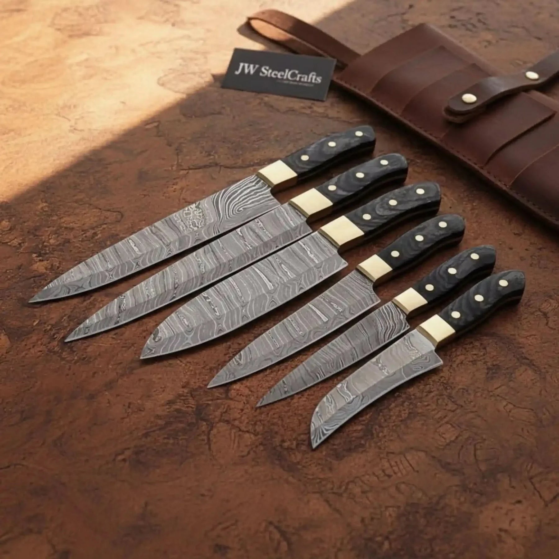 Handmade damascus steel knife with wood handle on dark surface