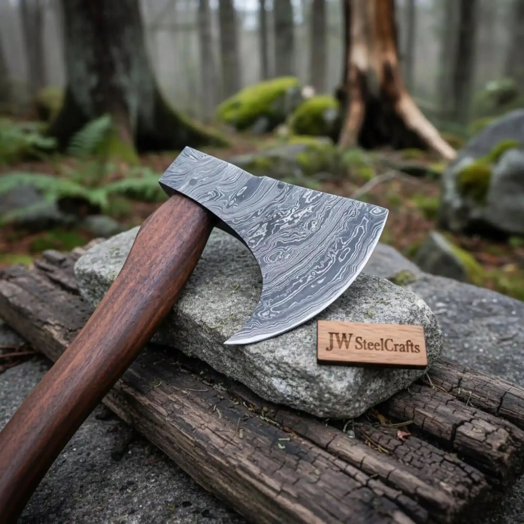 Damascus steel axe head with wood handle on rustic wood surface