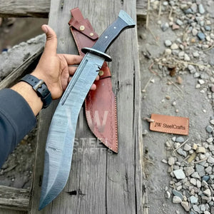 Handmade damascus steel knife with leather handle on dark surface