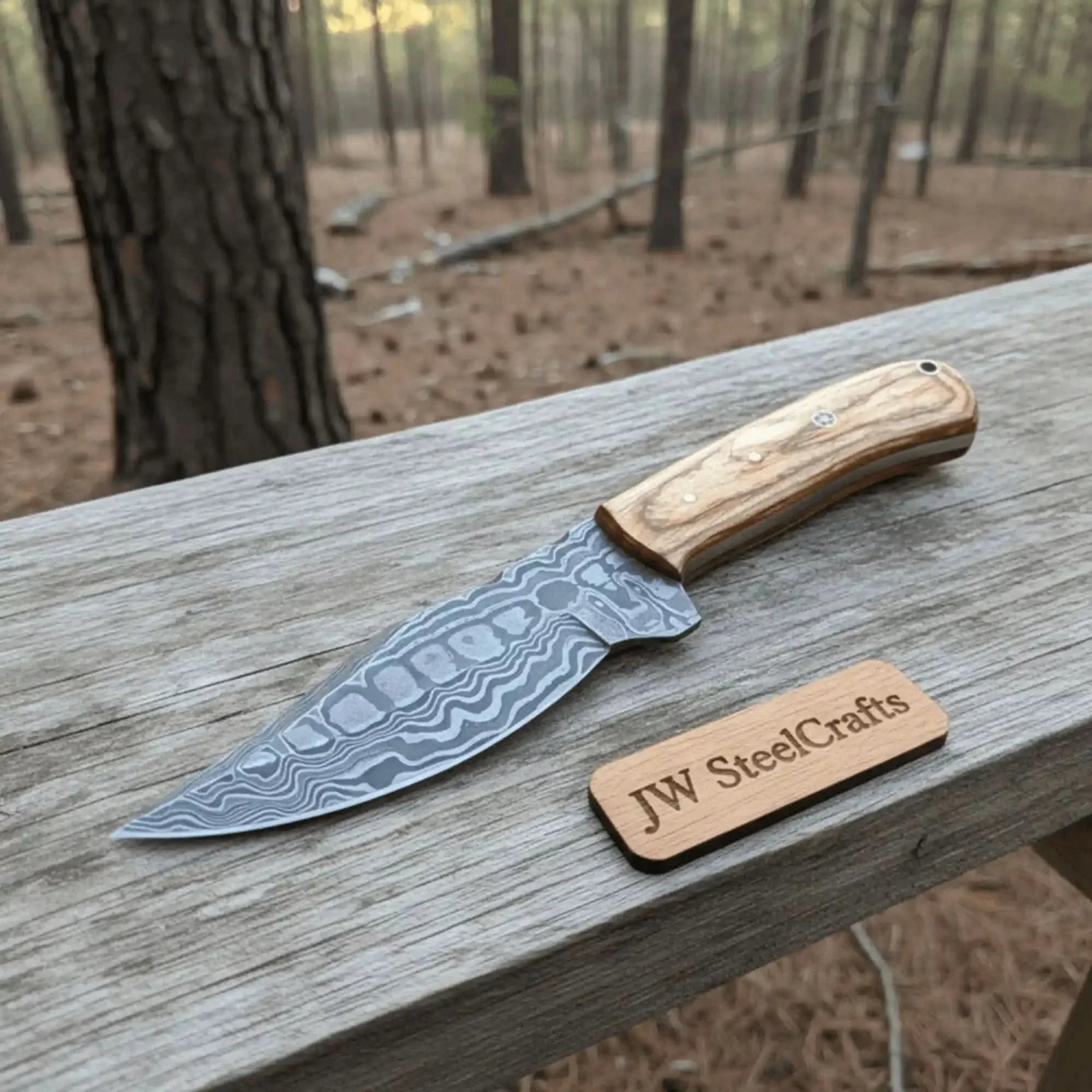 Handmade damascus steel knife with wood handle on dark surface