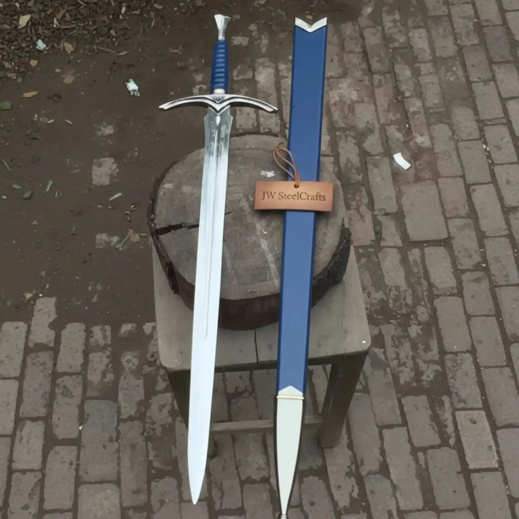 Full-length damascus steel replica sword with leather handle on dark background