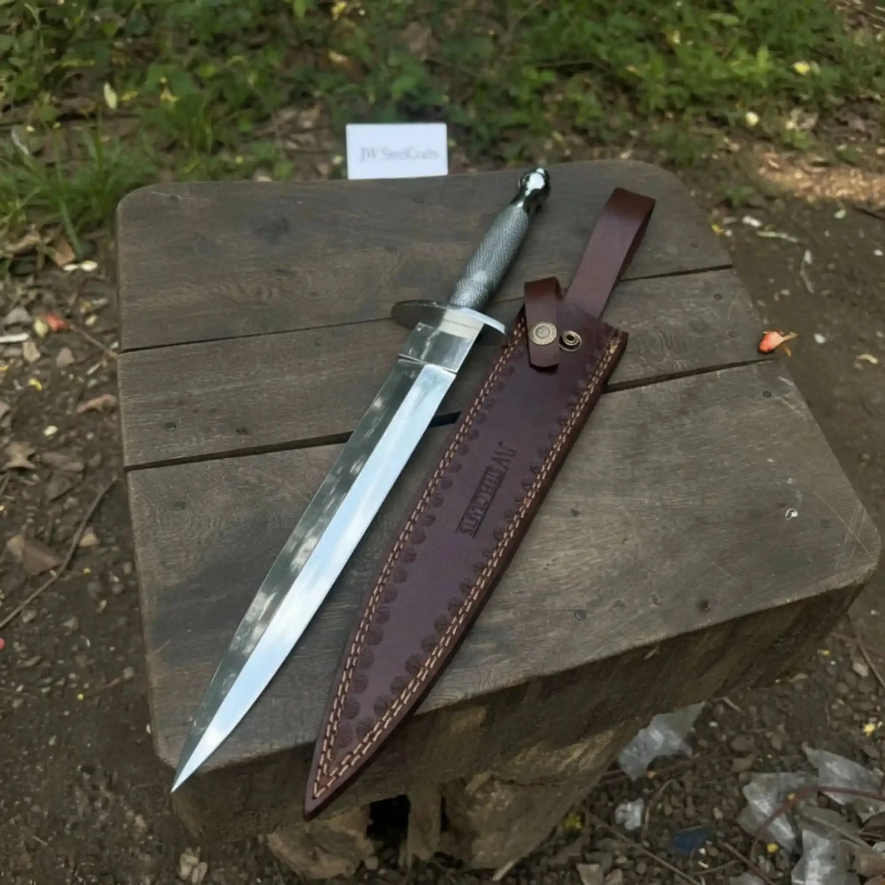 Handmade damascus steel knife with premium handle on dark surface
