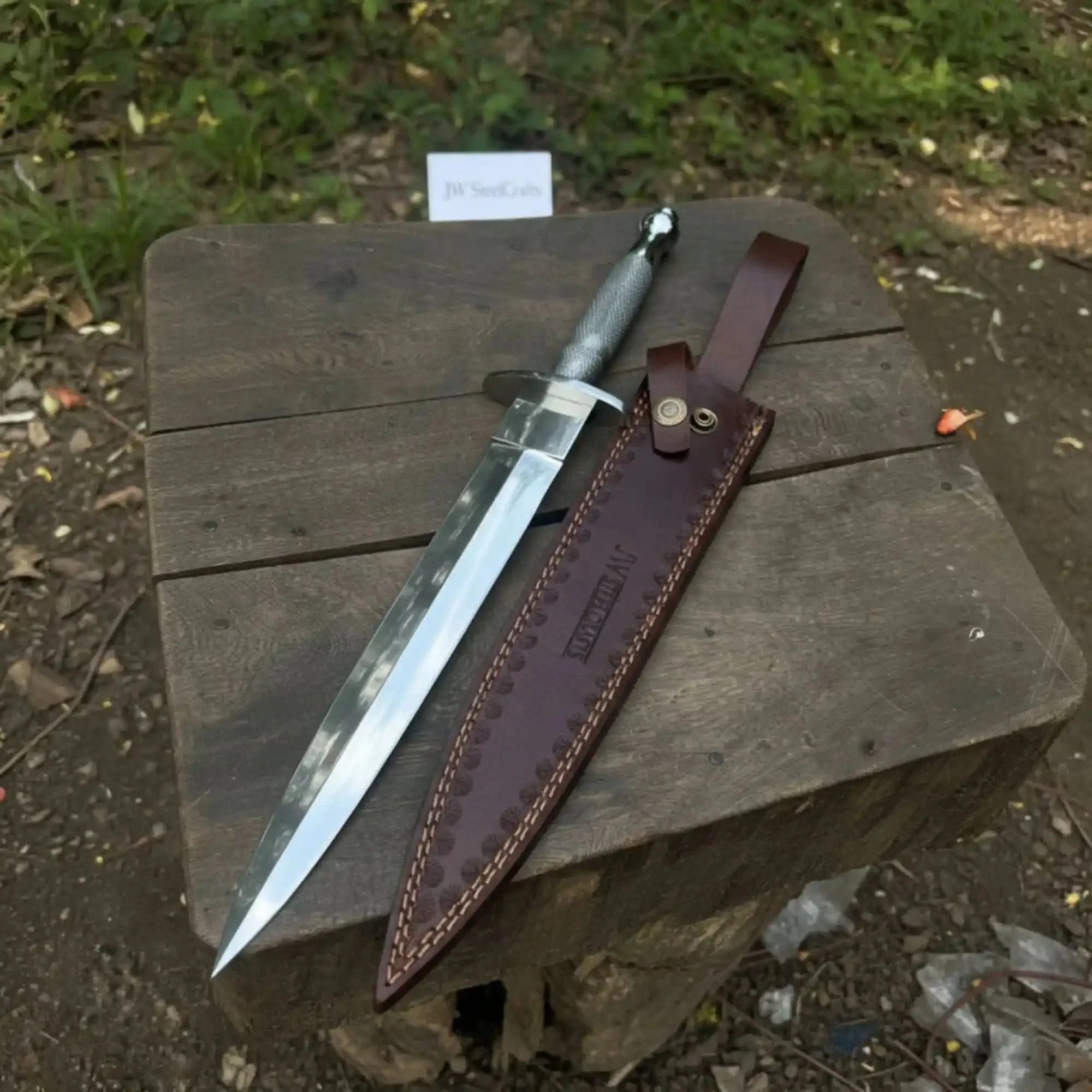 Handmade damascus steel knife with premium handle on dark surface