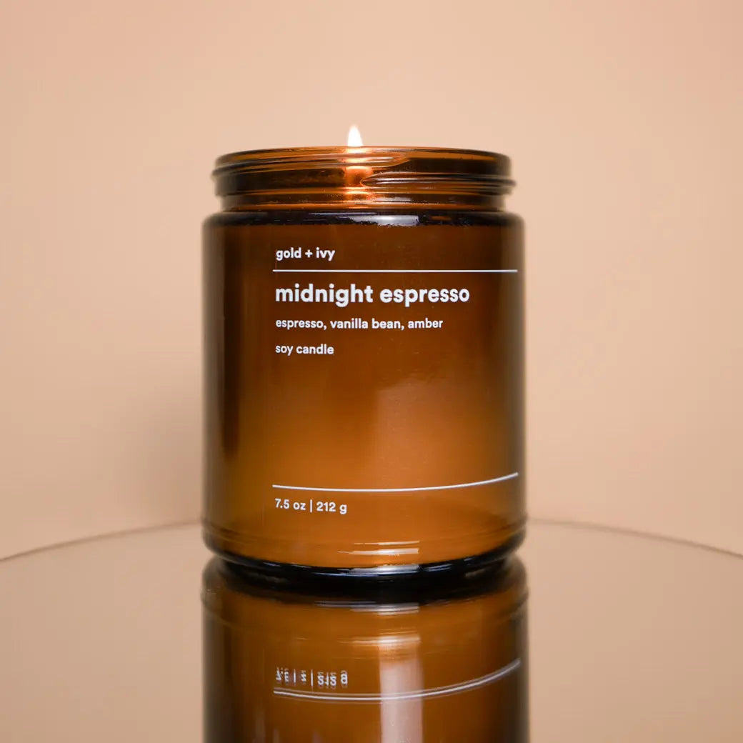 Midnight Espresso soy candle in amber glass jar with a lit wick.