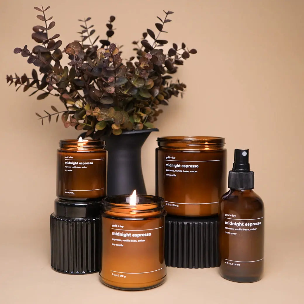 Gold + Ivy Midnight Espresso soy candle and room spray in amber glass bottles.