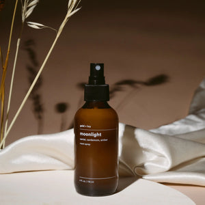 Gold + Ivy Moonlight room spray with sandalwood, cardamom, and amber notes in amber glass bottle.