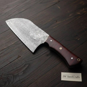 Handmade damascus steel knife with wood handle on dark surface