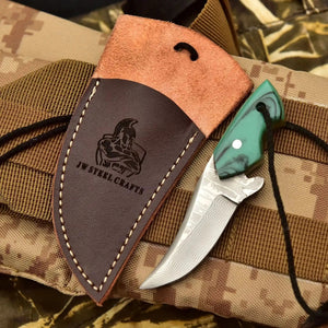 Handmade damascus steel knife with resin handle on dark surface