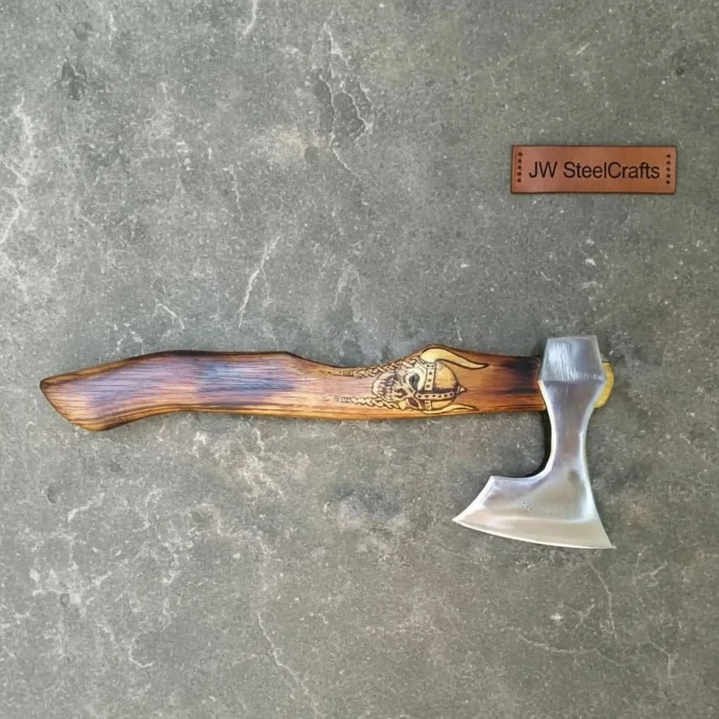Stainless steel steel axe head with wood handle on rustic wood surface