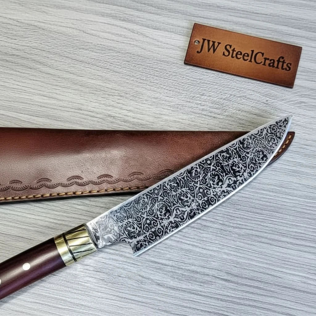 Handmade damascus steel knife with wood handle on dark surface