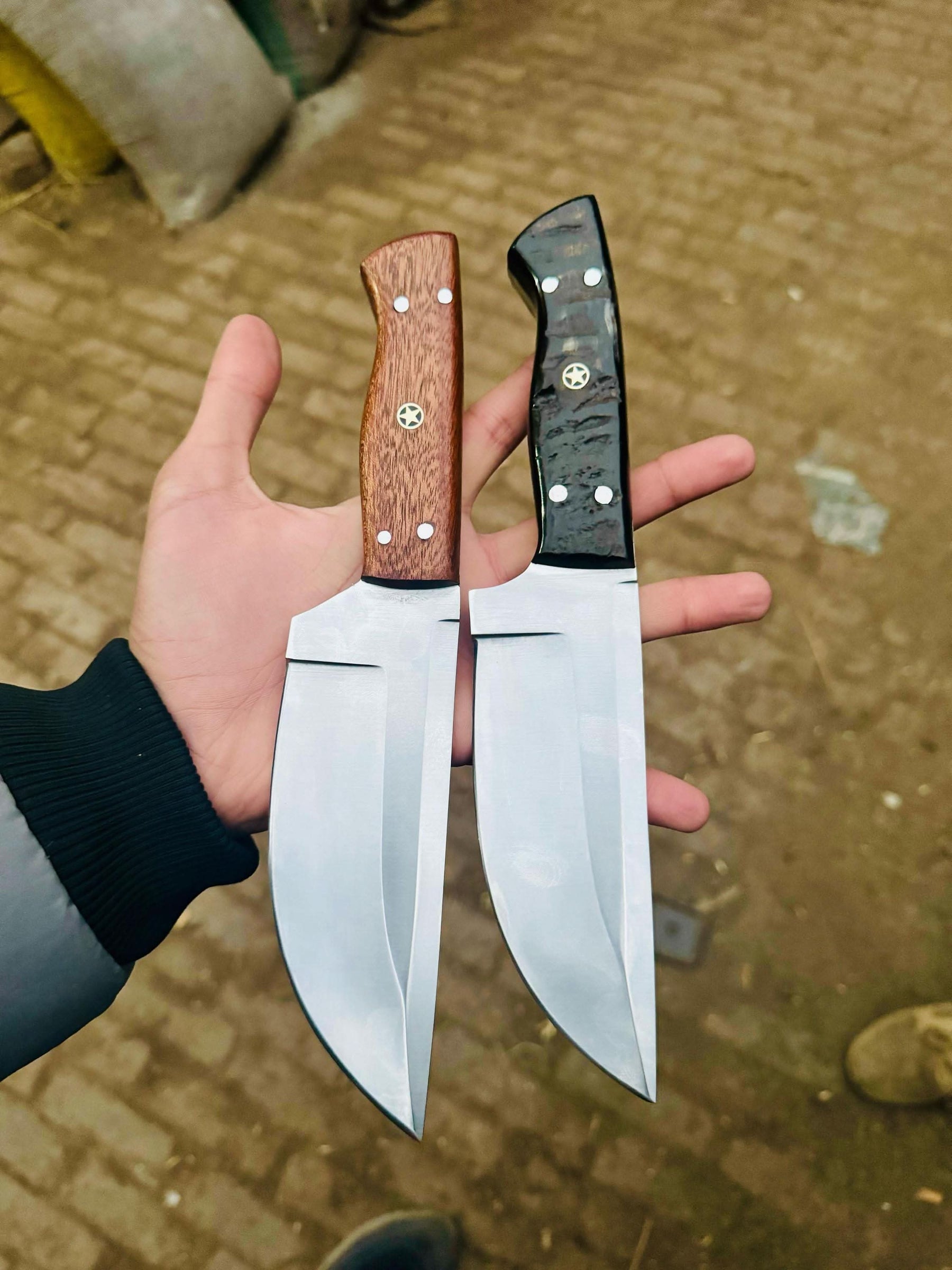 Handmade damascus steel knife with wood handle on dark surface