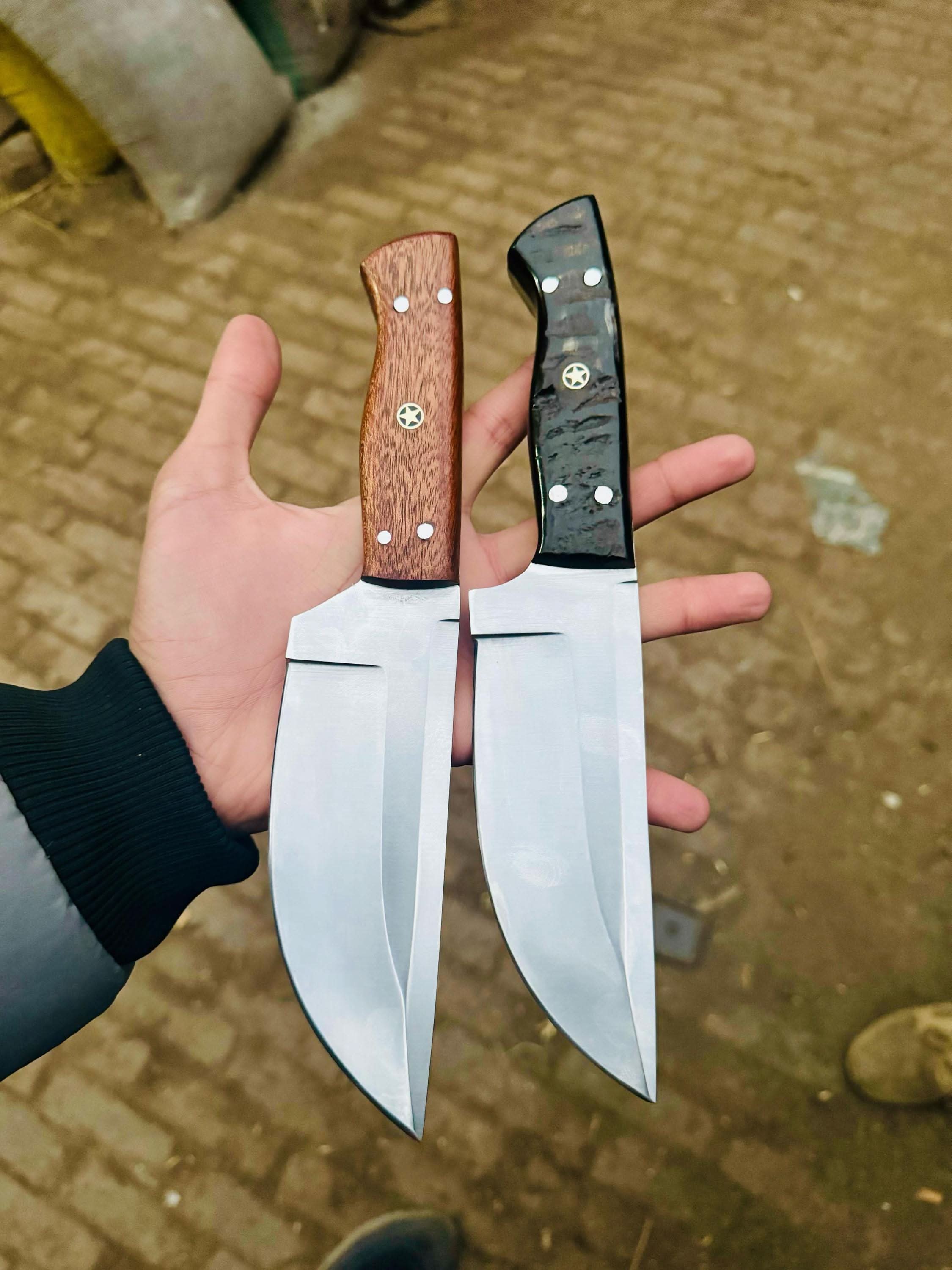 Handmade damascus steel knife with wood handle on dark surface
