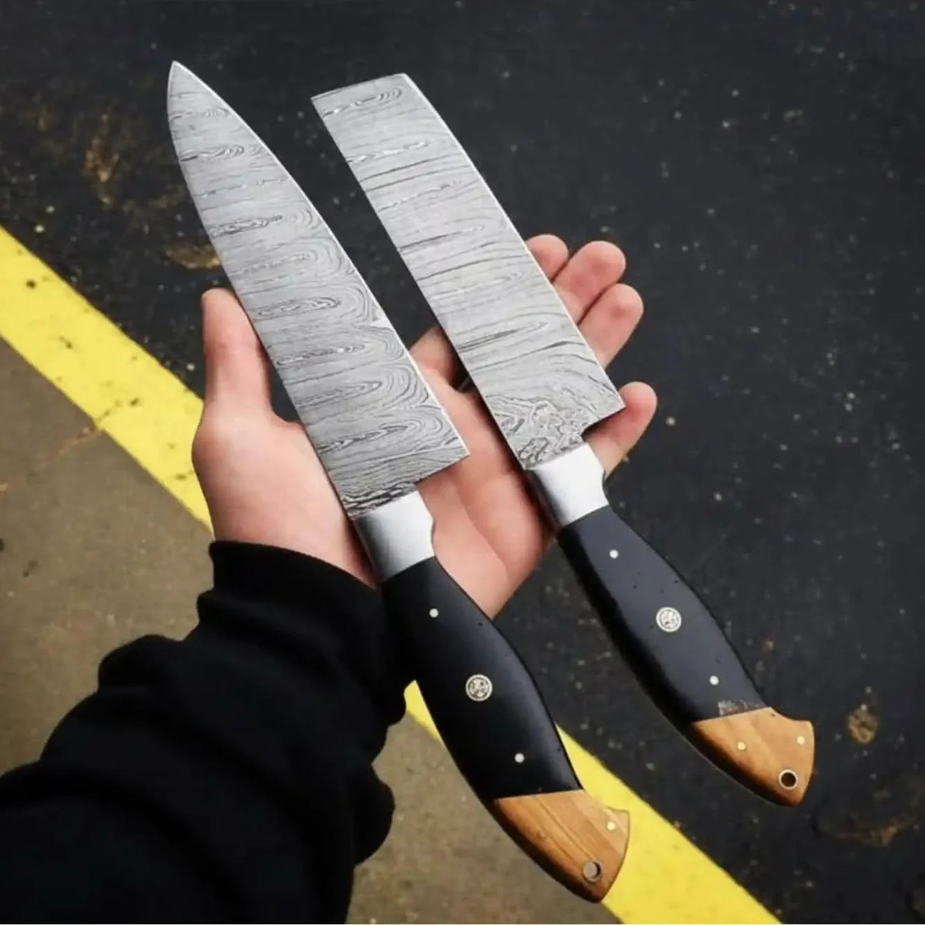 Handmade damascus steel knife with wood handle on dark surface