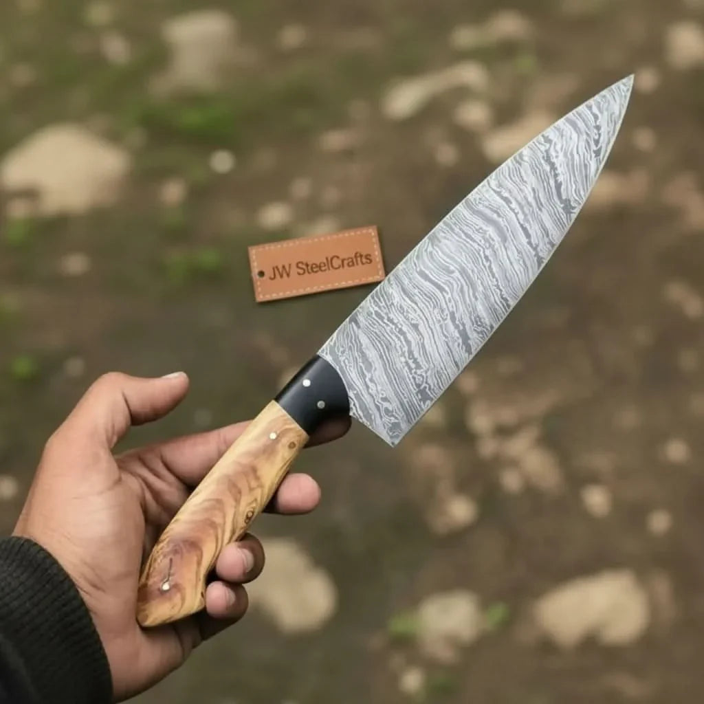 Handmade damascus steel knife with wood handle on dark surface